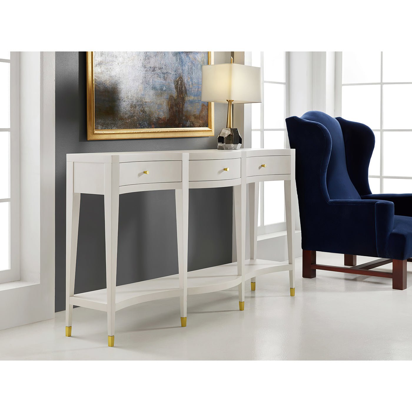 Console table with lamp and painting, elegant room setting.