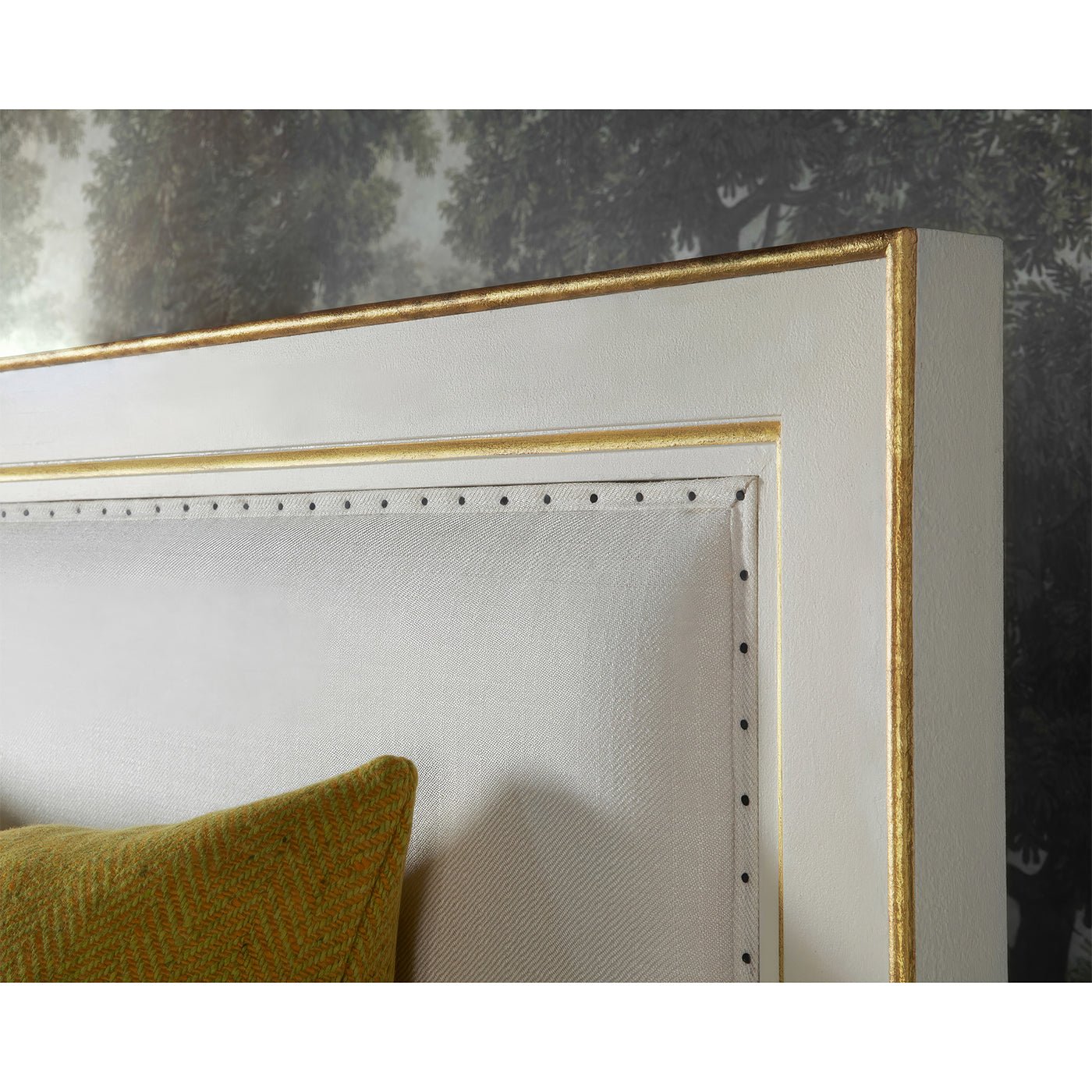 Close-up of bed headboard detailing with gold trim.