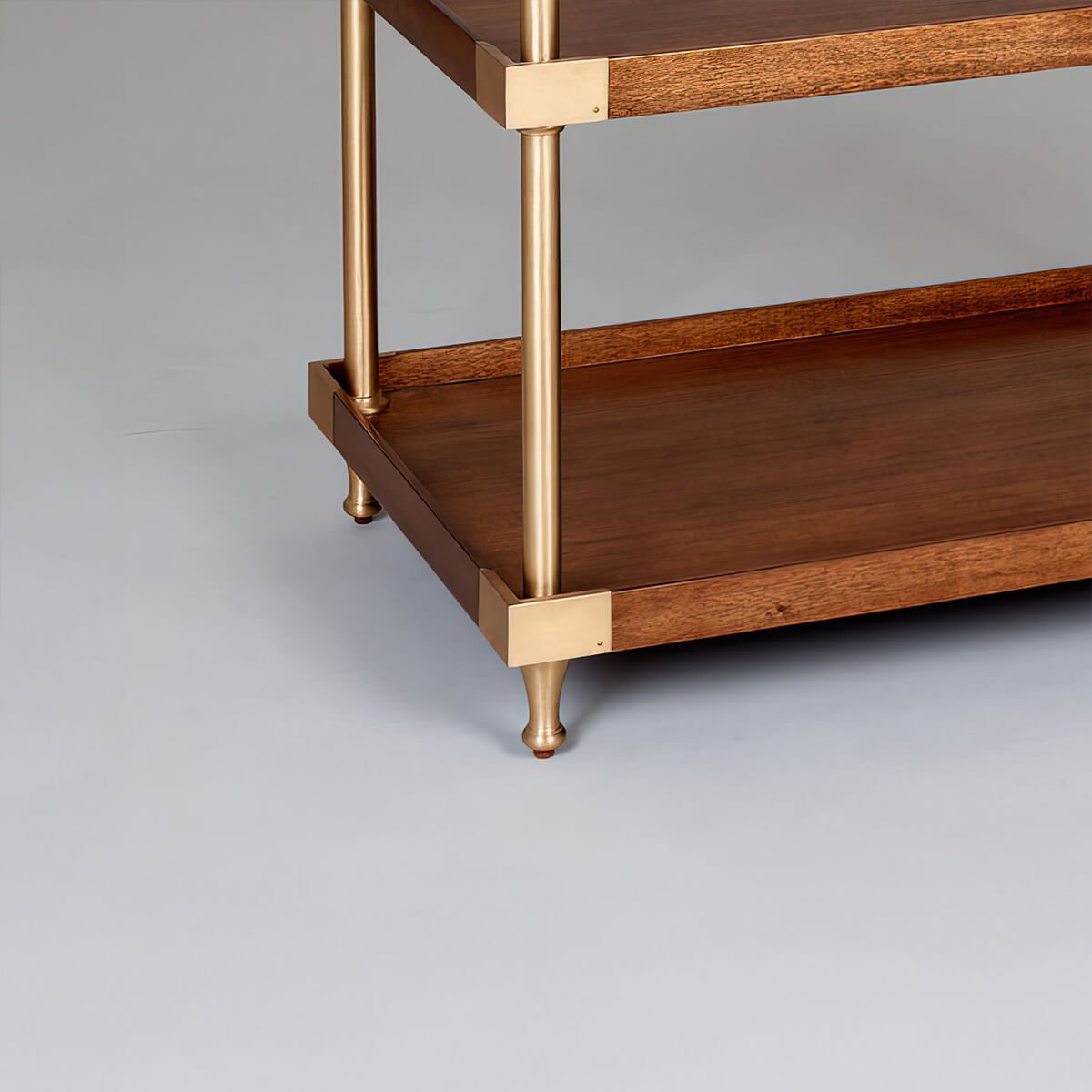 Bottom detail of wide modern etagere with gold legs.