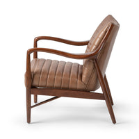 Side view of tan leather accent chair, showing curved ash arms and angled back