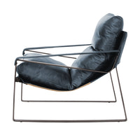 Side view of the Ocean Blue leather chair showing its low sling and open iron frame