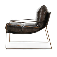 Side view of the Truffle Brown leather chair showing its curved sling and open iron frame