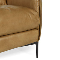 Close-up of tan leather seat cushion, piped side edge and slim black leg