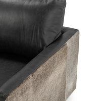Onyx Black swivel chair arm detail showing smooth leather beside hair on hide