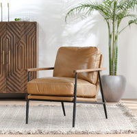Adobe Tan leather accent chair styled beside a wood cabinet and potted palm