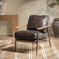 Truffle Brown leather accent chair with open arms styled on a striped rug