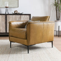 Adobe tan leather club chair with curved arms in a styled living room