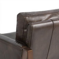 Rear corner detail of the Truffle Brown leather chair with piped upholstery and bronze-finished frame