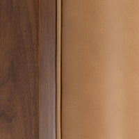 Tan leather and walnut shell edge close-up showing the upholstery piping