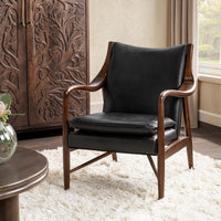 Jet Black leather accent chair with sculpted ash arms styled beside a carved cabinet