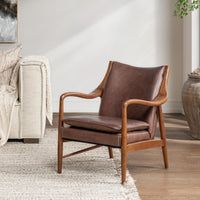 Barrel Brown leather accent chair with sculpted wood arms styled beside a sofa