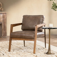 Truffle Brown leather accent chair with an ash frame styled beside a small pedestal table