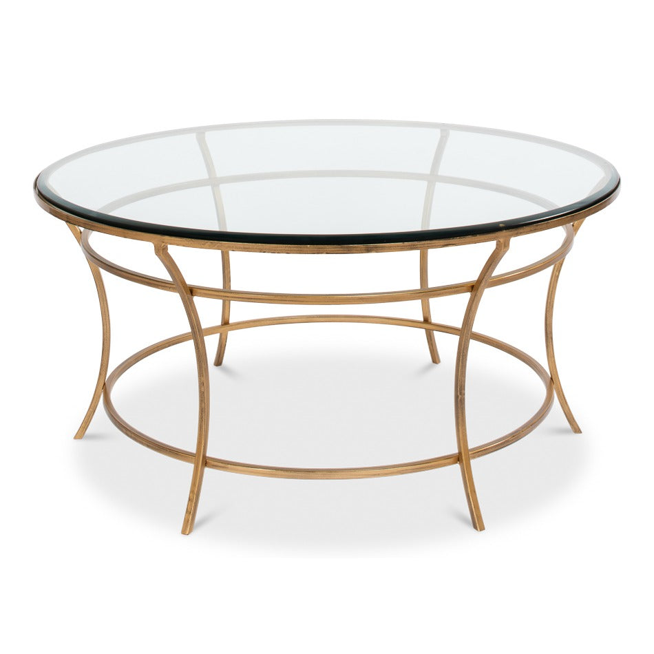 Round coffee table with clear glass top and open iron base in antique gold finish