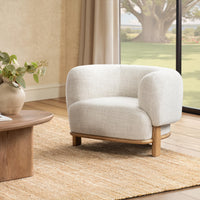 Natural barrel-back accent chair styled on a woven rug beside a low table