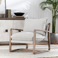 Natural sling-frame chair styled on a rug beside a cabinet and potted plant