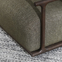 Close-up of Kale Green upholstery framed by a curved wood post and lower rail