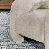 Close-up of the Sand chair's faux fur seat and curved arm in a room setting