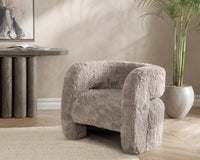 Granite faux fur chair styled beside a console table and potted plant