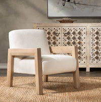 Ivory open-frame accent chair styled on a woven rug beside a patterned cabinet