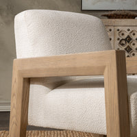 Side detail of the Ivory chair's oak arm and textured cushions in a room setting