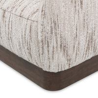 Close-up of the Cocoa Cream chair's upholstered front corner and dark wood base