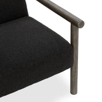 Close-up of the charcoal chair's textured seat and rounded wood arm joint