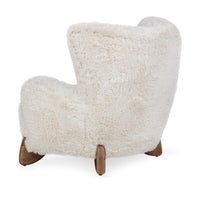 Rear three-quarter view of the Vanilla wingback chair's curved back and ash feet