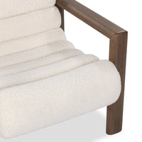 Close-up of the Ivory Fleece chair's padded channels and rounded-edge wood arm