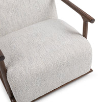 Close-up of the ivory chair's textured seat and rounded wood arm