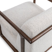 Elevated rear detail of the ivory chair's wood frame and rounded upholstered back
