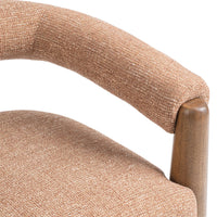 Close-up of the Desert Clay chair's horseshoe back, textured seat and wood post