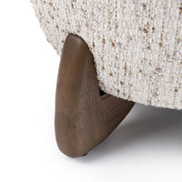 Shaped ash foot beneath the Canvas Oat chair's textured upholstery