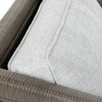 Close-up of the gray chair's back cushion seam and wrapped rattan frame