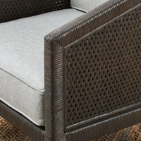 Close-up of the gray chair's open rattan weave and wrapped arm