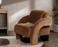 Bronze curved-arm accent chair styled on a patterned rug beside a fireplace