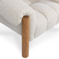 Close-up of the Cream chair's gathered arm upholstery and oak front leg