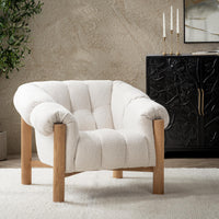 Cream channel-tufted chair styled on a pale rug beside a dark cabinet