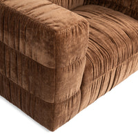 Close-up of the Bronze chair's gathered arm upholstery and seat folds