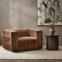 Bronze ruched swivel chair styled on a pale rug beside a round wood table