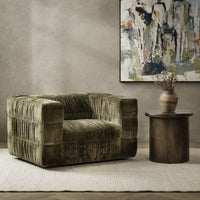 Olive Green ruched swivel chair styled on a pale rug beside a round wood table