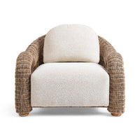 Front view of the Natural rattan chair with pale cushions and thick curved arms