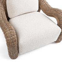 Close-up of the Natural rattan chair's pale cushions and curved woven arms