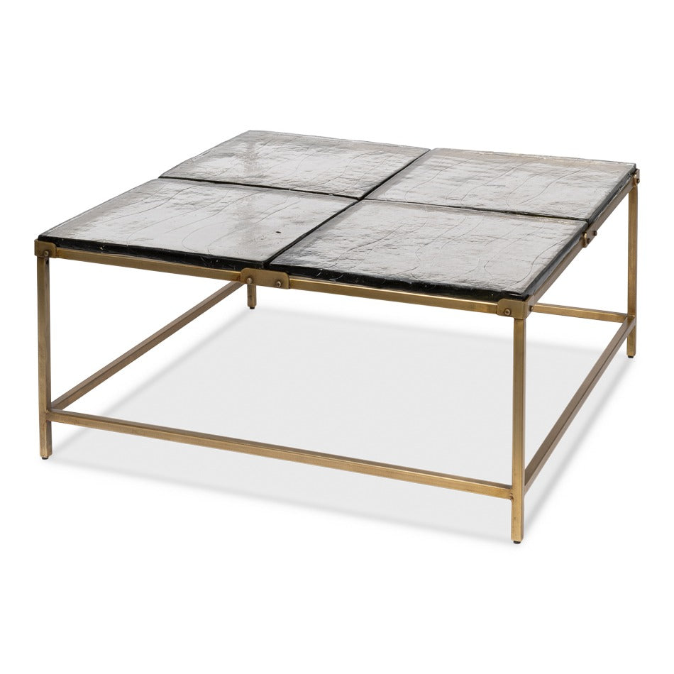 Contemporary 41-inch square coffee table with cast glass top in four quadrants and forged iron base in aged brass finish