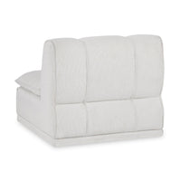 Rear three-quarter view of the white armless chair showing its channelled upholstered back