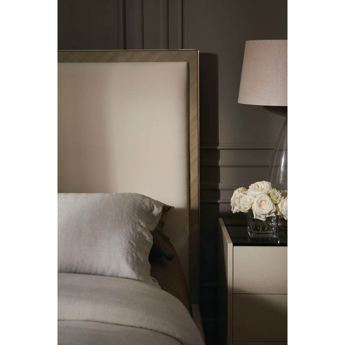Close-up of headboard and nightstand with flowers.