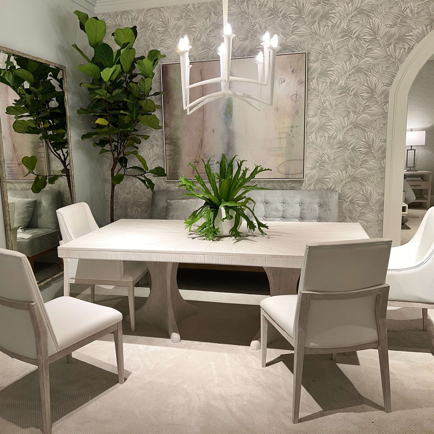 Elegant dining setting with white table and green plant.