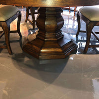 Close-up of ornate pedestal of round dining table.