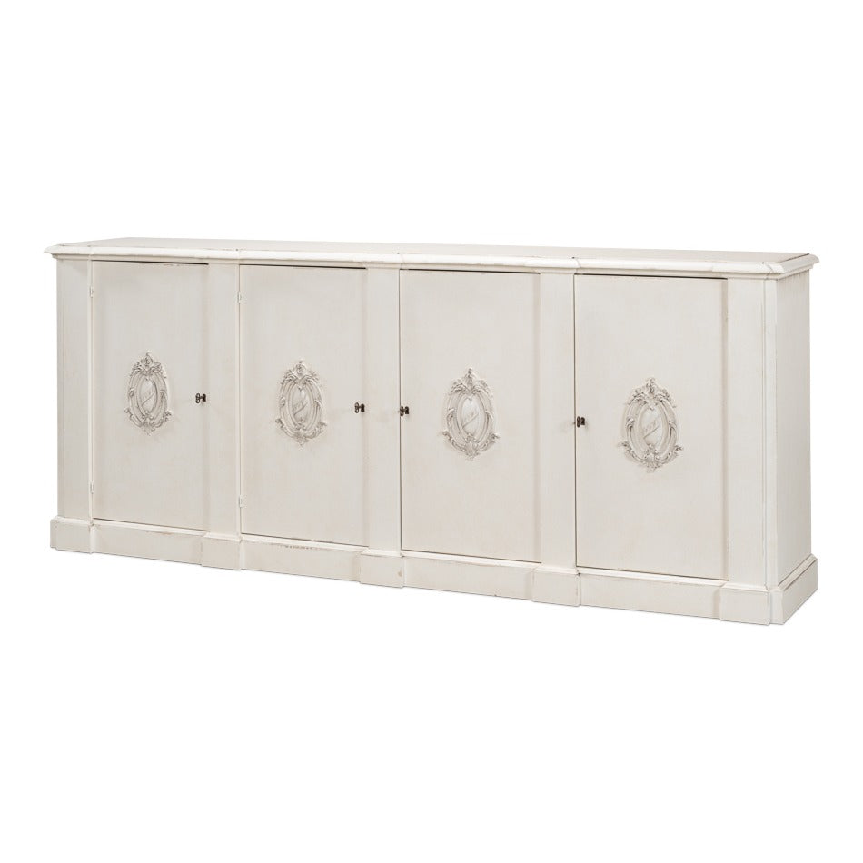 Long four-door white wall cabinet with carved crest appliqués and lightly distressed finish
