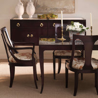 Dining room setup with wood chairs and floral cushions.