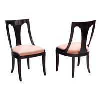 Pair of side chairs with dark wood and pink seats.